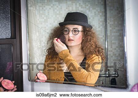 Woman applying makeup in mirror View Large Photo Image Stock Image - Woman applying makeup in mirror. Fotosearch