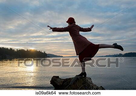 Picture - Woman balancing on rock formation. Fotosearch