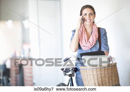 Stock Photo - Woman carrying box in bicycle basket. Fotosearch