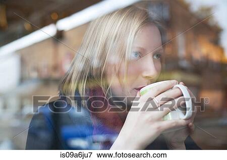 Stock Photo - Woman drinking cup of coffee in cafe. Fotosearch