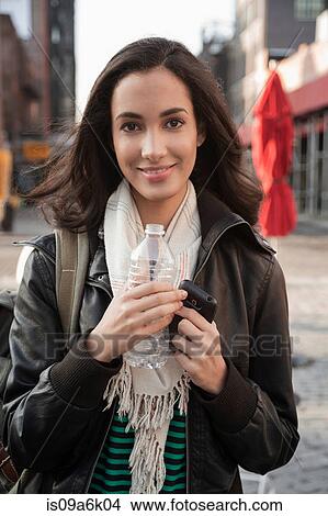 Woman drinking water on city street View Large Photo Image Picture - Woman drinking water on city street. Fotosearch
