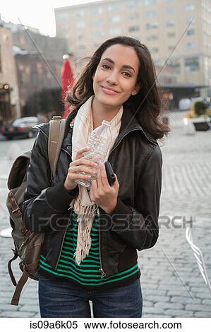 Woman drinking water on city street View Large Photo Image Stock Photography - Woman drinking water on city street. Fotosearch