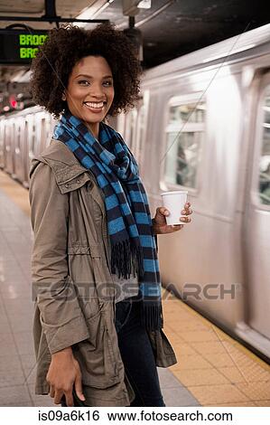 Woman having coffee at subway station View Large Photo Image Stock Photograph - Woman having coffee at subway station. Fotosearch