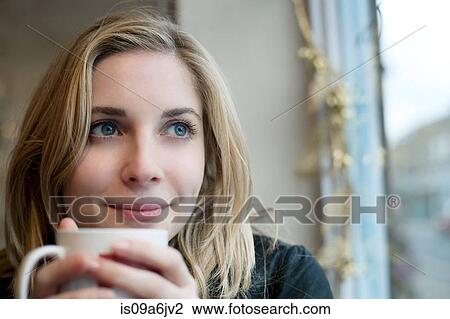Stock Image - Woman having cup of coffee in cafe. Fotosearch