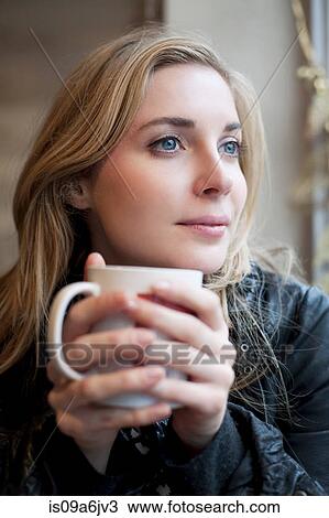 Stock Image - Woman having cup of coffee in cafe. Fotosearch
