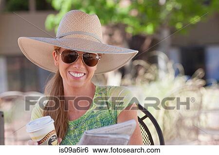 Stock Photograph - Woman having cup of coffee outdoors. Fotosearch