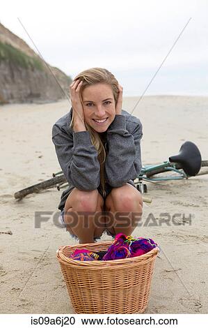 Stock Image - Woman having picnic on beach. Fotosearch