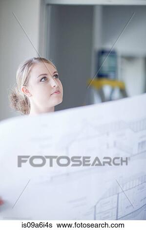 Woman holding blueprints in home View Large Photo Image Stock Photograph - Woman holding blueprints in home. Fotosearch