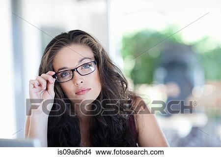 Woman holding glasses at desk View Large Photo Image Picture - Woman holding glasses at desk. Fotosearch
