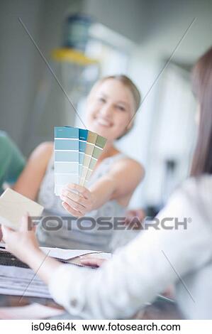 Stock Image - Woman holding paint swatches. Fotosearch