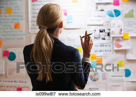 Stock Photo - Woman holding pen, rear view. Fotosearch