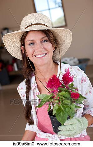 Stock Image - Woman holding potted plant. Fotosearch
