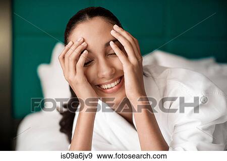 Woman in bathrobe smiling on bed View Large Photo Image Stock Photo - Woman in bathrobe smiling on bed. Fotosearch