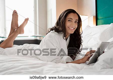 Woman in bathrobe using tablet computer View Large Photo Image Stock Photo - Woman in bathrobe using tablet computer. Fotosearch