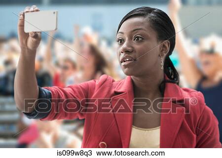 Woman in stadium, recording event with her phone View Large Photo Image Stock Image - Woman in stadium, recording event with her phone. Fotosearch