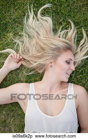 Stock Photography - Woman laying in grass. Fotosearch