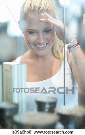 Woman looking in glass case in store View Large Photo Image Stock Photo - Woman looking in glass case in store. Fotosearch