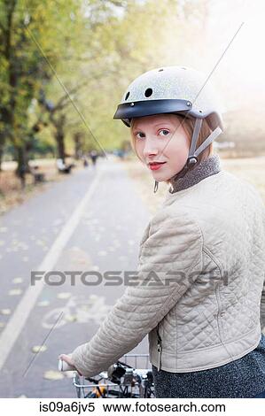 Stock Photography - Woman on bicycle in urban park. Fotosearch