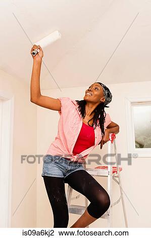 Woman painting in new home View Large Photo Image Stock Image - Woman painting in new home. Fotosearch