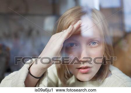 Stock Image - Woman peering through window. Fotosearch