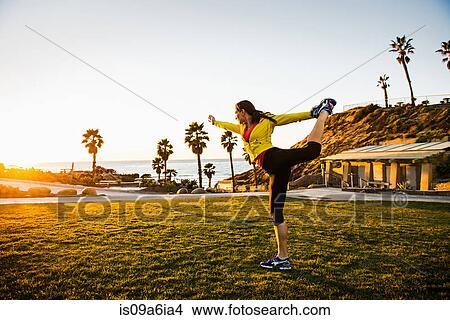 Woman practicing yoga on green lawn View Large Photo Image Picture - Woman practicing yoga on green lawn. Fotosearch