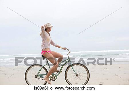 Woman riding bicycle on beach View Large Photo Image Picture - Woman riding bicycle on beach. Fotosearch