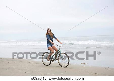 Woman riding bicycle on beach View Large Photo Image Stock Photo - Woman riding bicycle on beach. Fotosearch