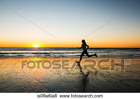 Stock Photo - Woman running on beach. Fotosearch