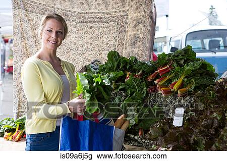Woman shopping at farmer's market View Large Photo Image Stock Image - Woman shopping at farmer's market. Fotosearch