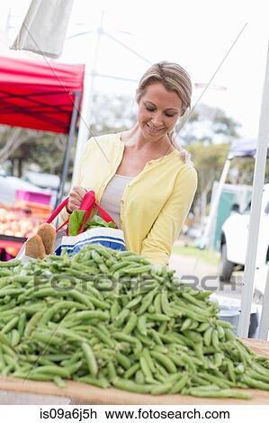 Stock Image - Woman shopping at farmer's market. Fotosearch