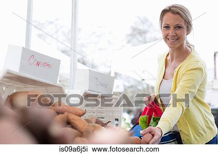 Stock Image - Woman shopping at farmer's market. Fotosearch
