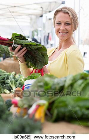 Stock Image - Woman shopping at farmer's market. Fotosearch