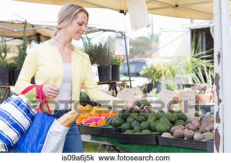 Stock Image - Woman shopping at farmer's market. Fotosearch