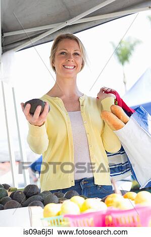 Stock Image - Woman shopping at farmer's market. Fotosearch