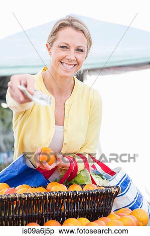 Stock Photography - Woman shopping at farmer's market. Fotosearch