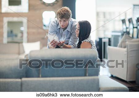 Stock Image - Woman shopping with salesman in store. Fotosearch