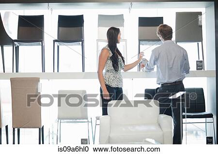 Stock Image - Woman shopping with salesman in store. Fotosearch