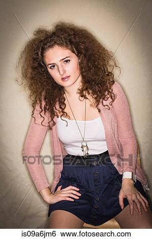 Stock Photograph - Woman sitting in corner. Fotosearch