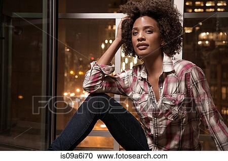 Stock Image - Woman sitting in windowsill. Fotosearch
