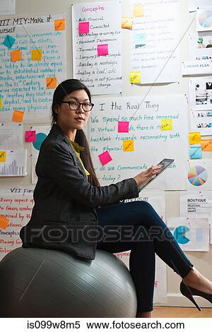 Woman sitting on exercise ball with digital tablet View Large Photo Image Stock Photography - Woman sitting on exercise ball with digital tablet. Fotosearch