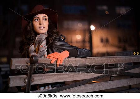 Stock Photograph - Woman sitting on park bench. Fotosearch