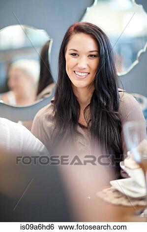Stock Photograph - Woman smiling at dinner table. Fotosearch
