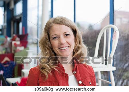 Woman smiling in thrift store View Large Photo Image Stock Image - Woman smiling in thrift store. Fotosearch