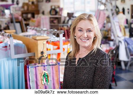 Woman smiling in thrift store View Large Photo Image Stock Photo - Woman smiling in thrift store. Fotosearch
