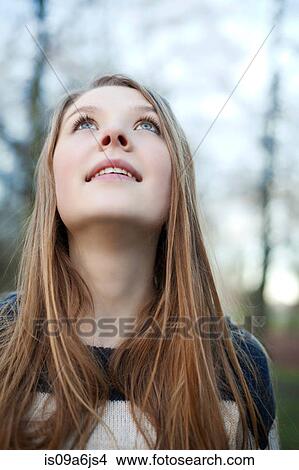 Picture - Woman standing in park. Fotosearch