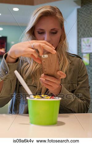 Woman taking picture of frozen yogurt View Large Photo Image Stock Photo - Woman taking picture of frozen yogurt. Fotosearch