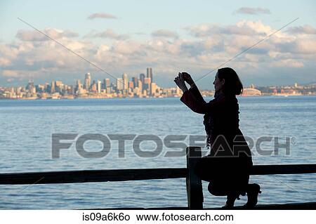 Woman taking picture of Seattle skyline View Large Photo Image Picture - Woman taking picture of Seattle skyline. Fotosearch