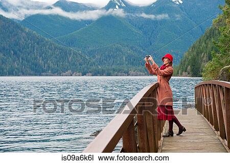 Woman taking picture on wooden bridge View Large Photo Image Stock Image - Woman taking picture on wooden bridge. Fotosearch