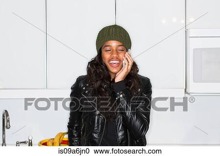 Woman talking on cell phone in kitchen View Large Photo Image Stock Image - Woman talking on cell phone in kitchen. Fotosearch