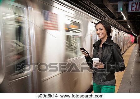 Woman using cell phone at subway station View Large Photo Image Picture - Woman using cell phone at subway station. Fotosearch